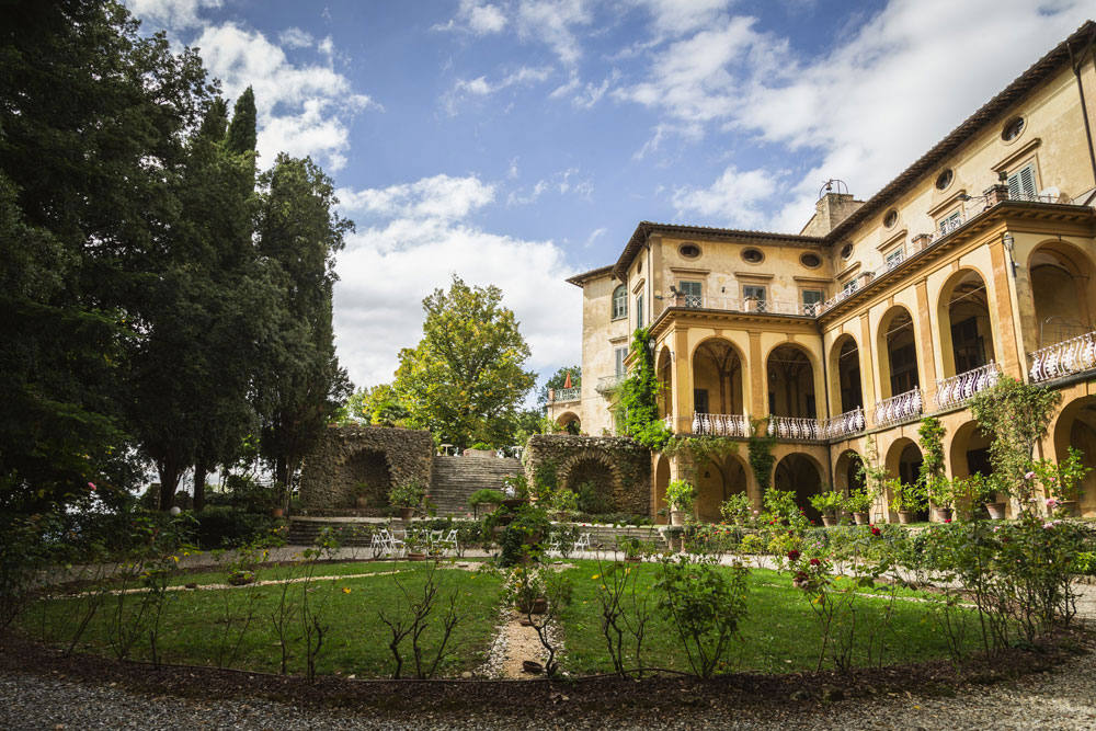 The villa's arched loggia above its formal rose garden